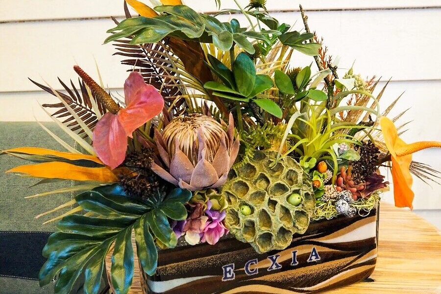 黒い器に金色の花をあしらったサンドアートの記念品