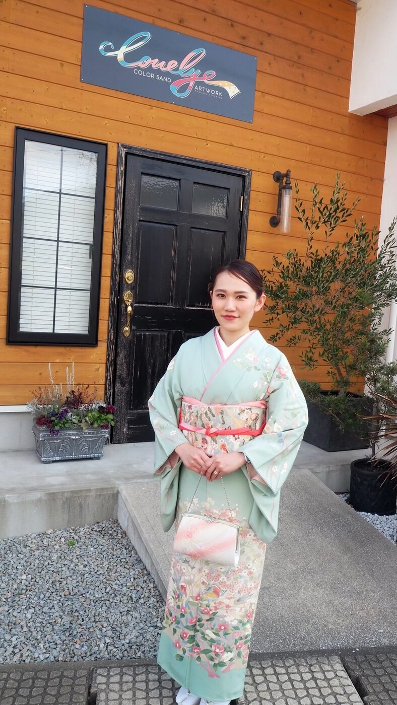 淡い色の訪問着をまとったお母さま。サロンの前にて