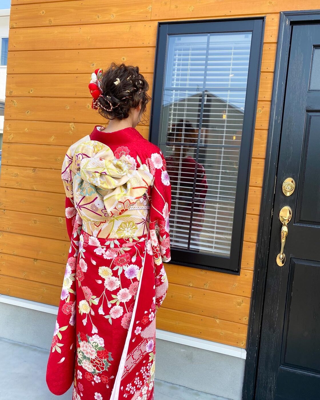 サロン前に立つ成人式の振袖姿。後ろ姿の帯と髪型