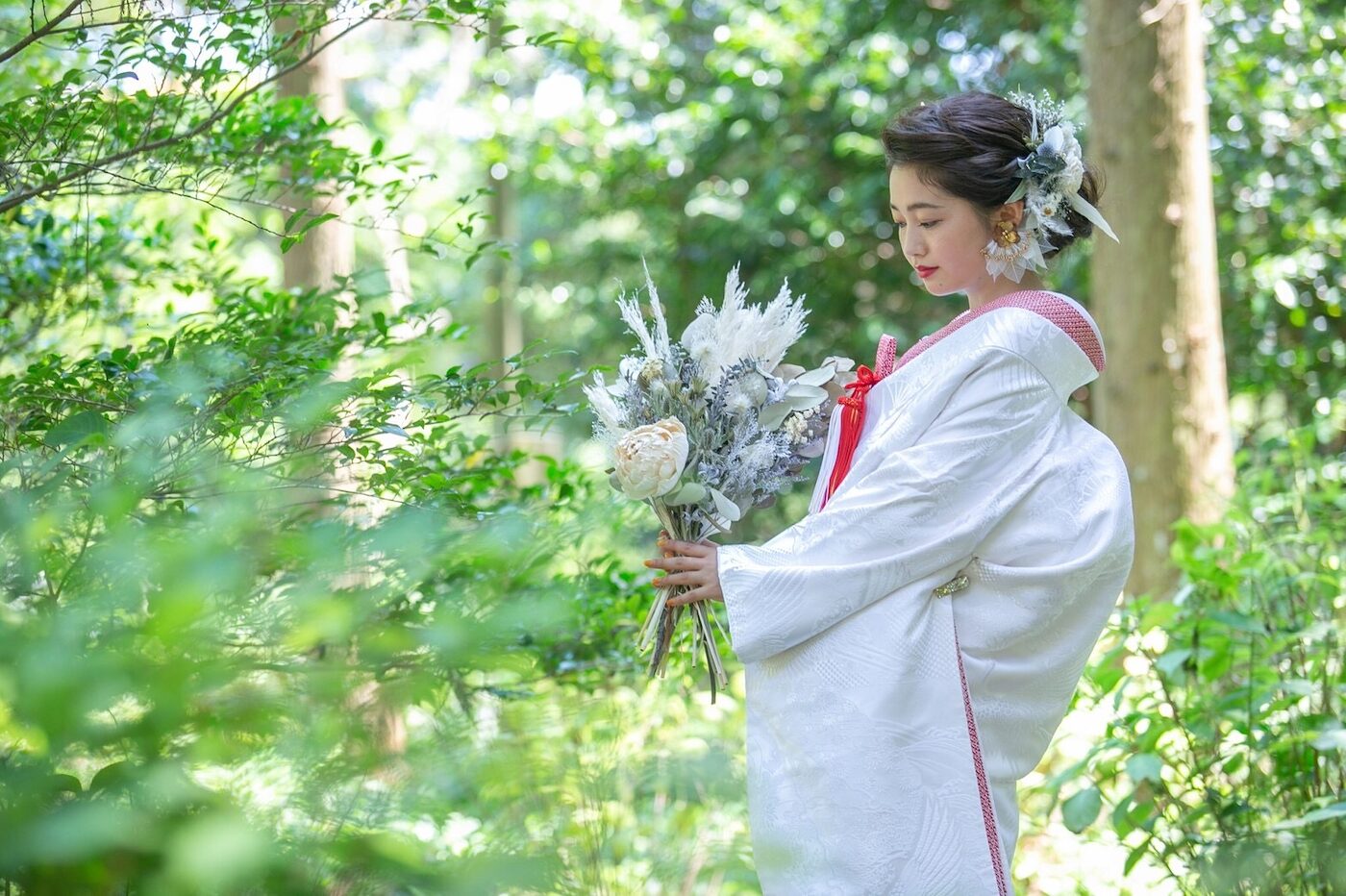 白無垢に洋髪を合わせた花嫁。緑の中でブーケを持つ姿