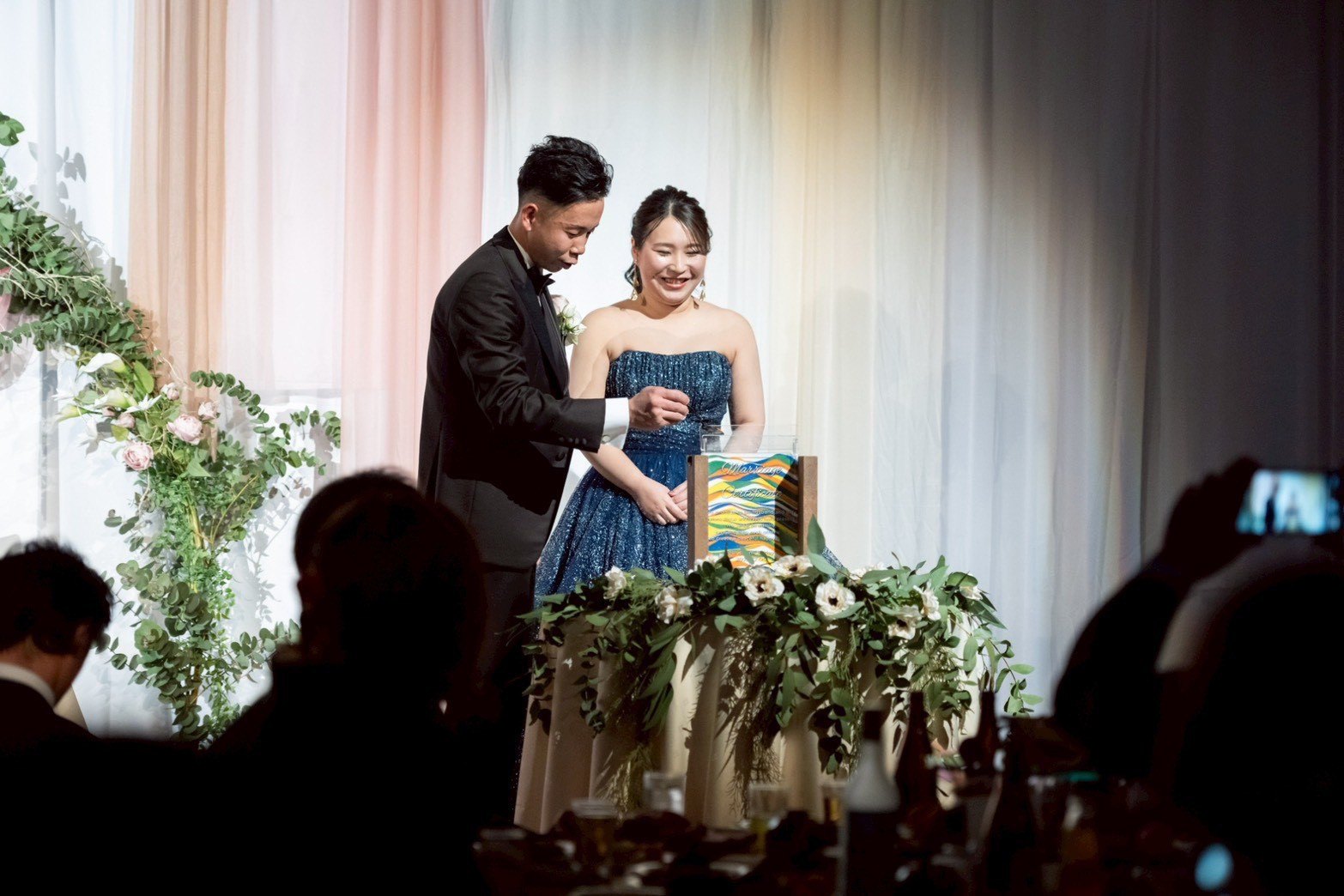 高砂で完成した結婚証明書を前にする新郎新婦