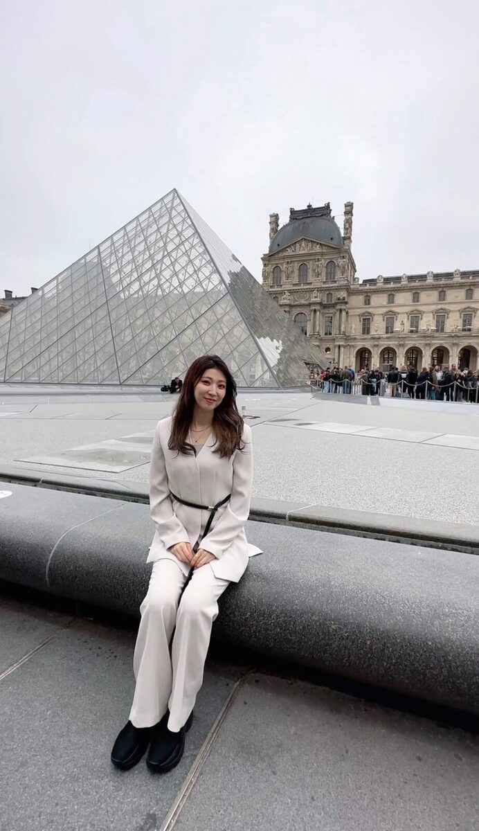 パリ・ルーヴル美術館前に立つ井上真衣子